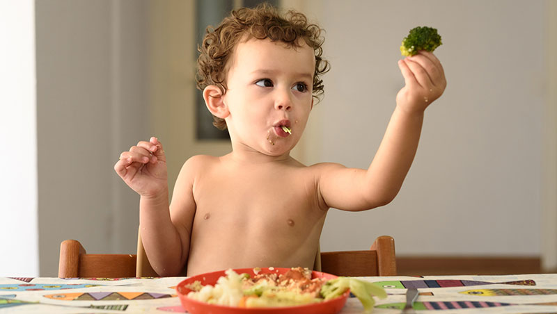 niño pequeño comiendo verduras