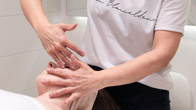 mujer dando masaje facial con las manos