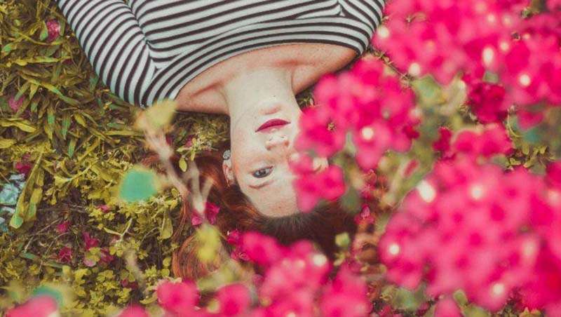 chica tumbada flores rosas