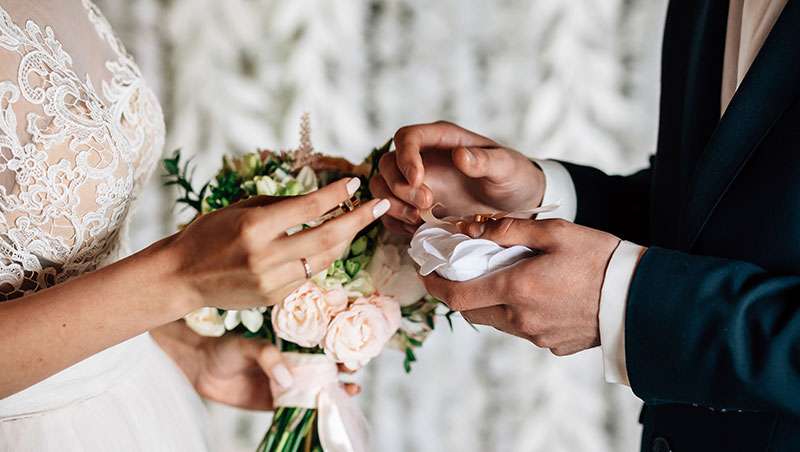 novios boda chico poniendo anillo ramo de flores