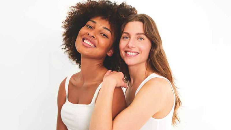 chicas abrazandose sonriendo posando para foto con camiseta blanca